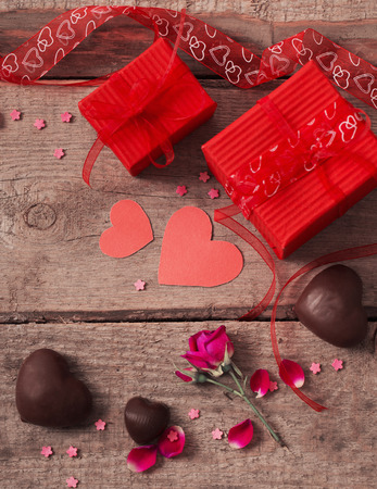 valentine gift box and red heart shapes on wooden boardの写真素材