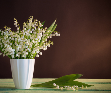 Lilly of valley in  vase on dark backgroundの写真素材