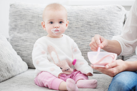 Mom feeding baby indoorの写真素材