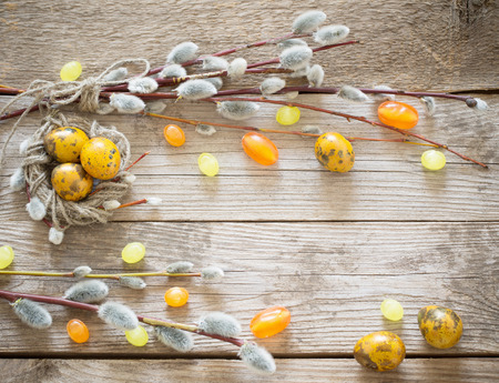 Easter eggs and willow branches on wooden backgroundの写真素材