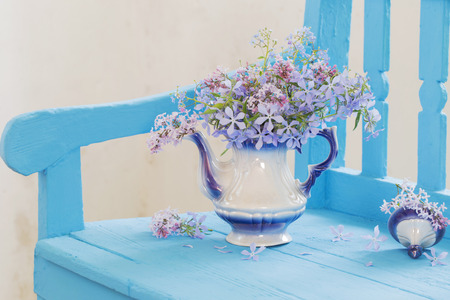 still life with spring flowers on blue benchの写真素材