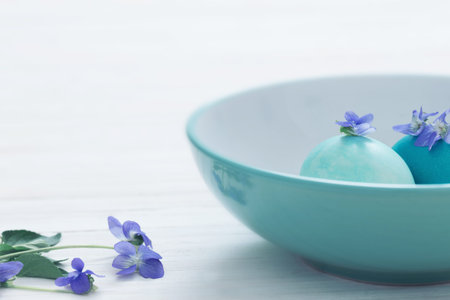 aster eggs with flowers on white wooden tableの写真素材