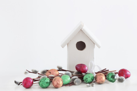 Easter eggs and birdhouse on white backgroundの写真素材