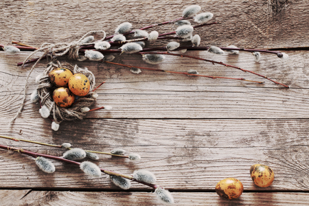 Easter eggs and willow branches on wooden backgroundの写真素材