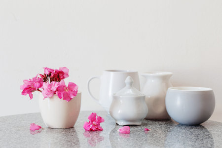 Clean dishes and flowers on white backgroundの写真素材