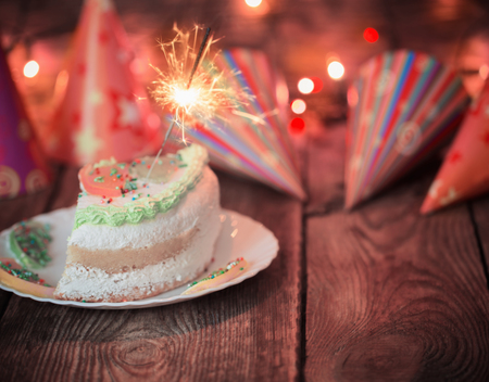 cake with sparkler on table on wooden backgroundの写真素材