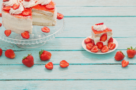 cake with strawberries on blue wooden tableの写真素材