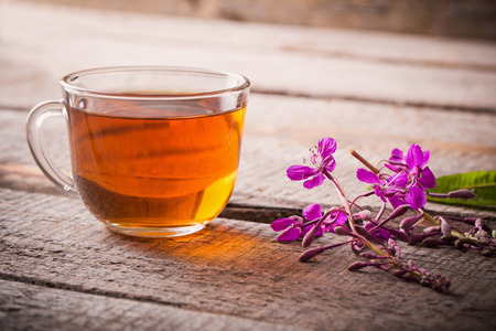 cup of tea with willow-herb on wooden backgroundの写真素材