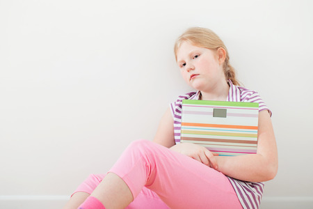 sad girl with scales indoorの写真素材