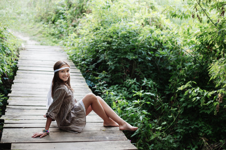 beautiful girl on old wooden bridge in forestの写真素材