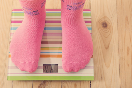 Feet on scales on wooden floorの写真素材