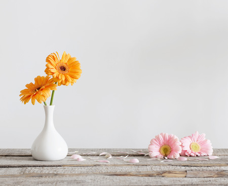 Gerbera in vase on old wooden tableの写真素材