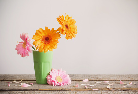 Gerbera in vase on old wooden tableの写真素材