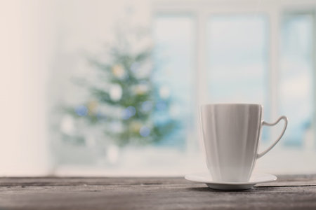 white cup on background Christmas fir and windowの写真素材