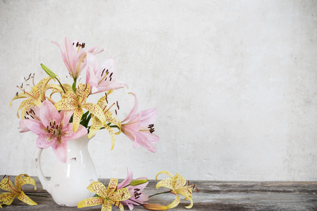 lily in vase on background old white wallの写真素材