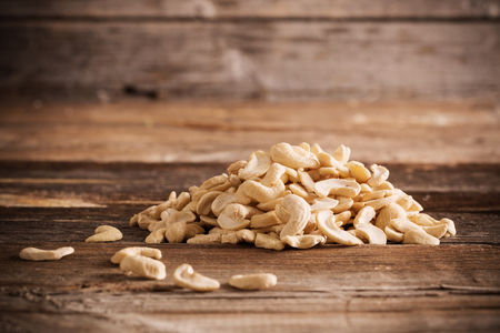 Roasted cashews on natural wooden table backgroundの写真素材