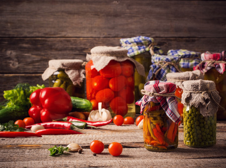 Preserved and fresh vegetables on wooden backgroundの写真素材
