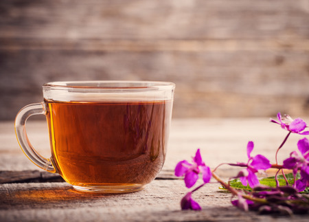 cup of tea with willow-herb on wooden backgroundの写真素材