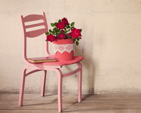 roses on old chair on background grunge wallの写真素材