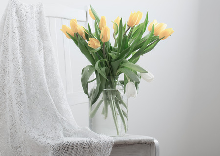 yellow flowers on chair indoorの写真素材
