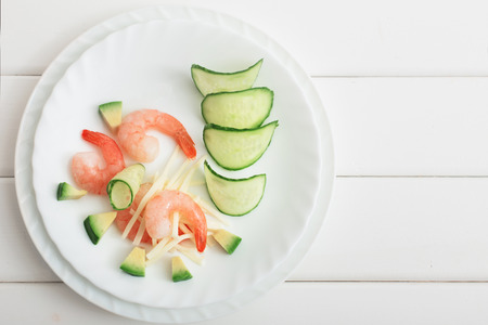 Cooked shrimps with avocado and mozzarella on white wooden tableの写真素材