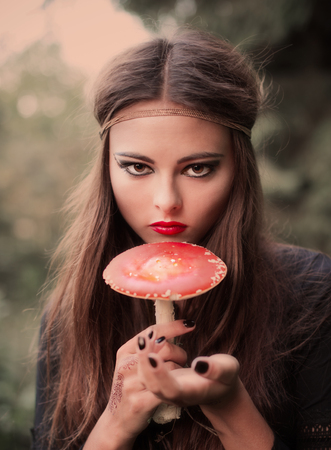 beautiful witch holding a mushroomの写真素材