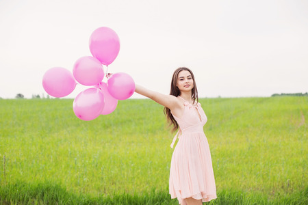 girl with balloons  in a fieldの写真素材