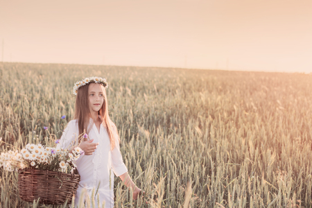 girl in the wheat field with basket of flowersの写真素材