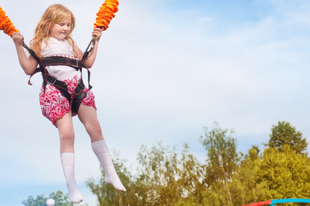 happy girl jumping in amusement parkの写真素材