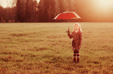 little girl with umbrella outdoorの写真素材