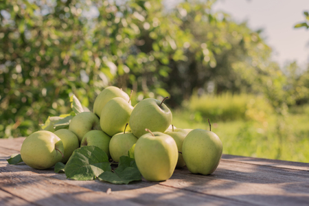 green apples on wooden table outdoorの写真素材