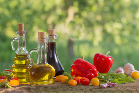 vegetables with oil on wooden table outdoorの写真素材