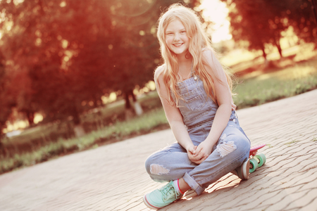 teen girls with with skateboard in summer parkの写真素材