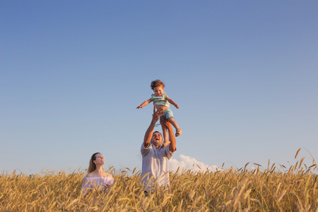 happy family in cereal field at sunsetの写真素材