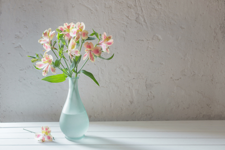 Alstroemeria in vase on grunge white backgroundの写真素材