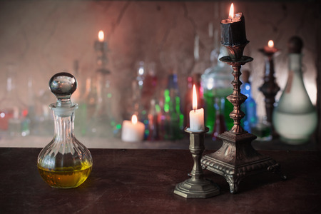 Magic potion, ancient books and candles on dark backgroundの写真素材