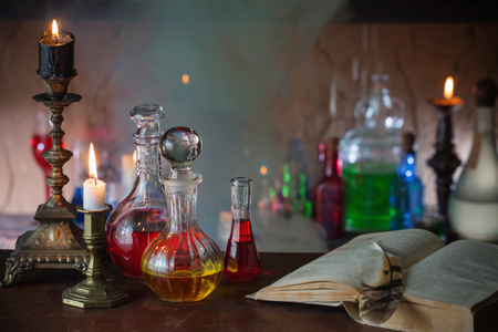 Magic potion, ancient books and candles on dark backgroundの写真素材