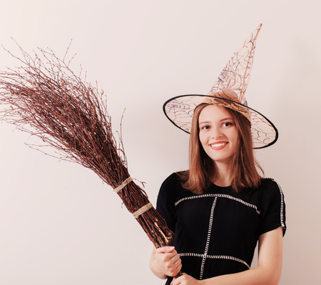 young beautiful witch on background white wallの写真素材