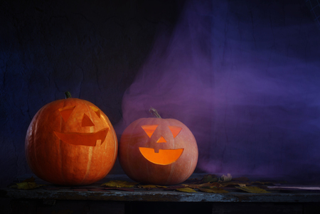 Halloween pumpkins on wooden table on dark backgroundの写真素材