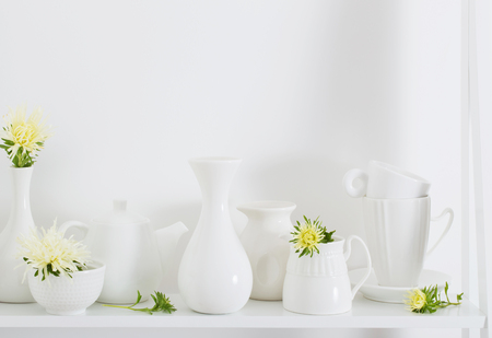 white dishware with flowers on wooden shelfの写真素材