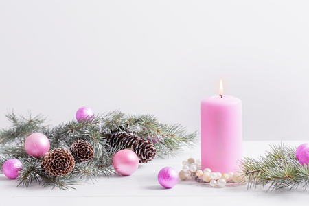 Christmas decoration with pink candle on white backgroundの写真素材