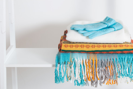 scarves and gloves on white wooden shelfの写真素材