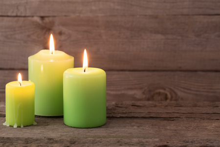 green candles on dark wooden backgroundの写真素材