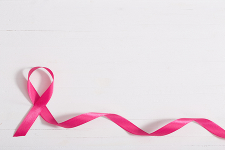 healthcare and medicine concept. pink breast cancer awareness ribbon on wooden white backgroundの写真素材