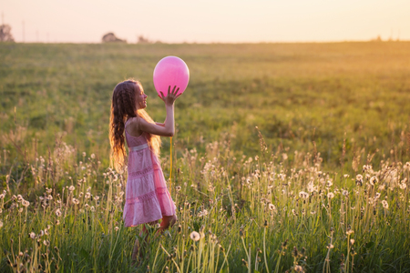 happy girl with balloon at sunsetの写真素材