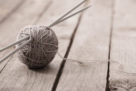 Knitting and knitting needles on a wooden surfaceの写真素材