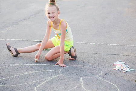 happy girl drawing chalk on  asphaltの写真素材