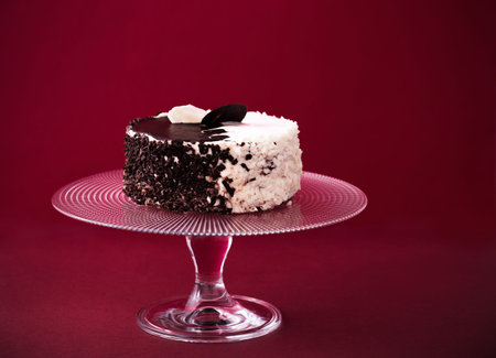 cake on glass plate on red background