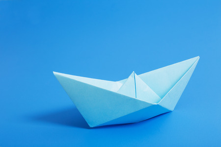paper boat on blue paper backgroundの写真素材