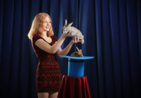 girl shows focus with a rabbit in a hatの写真素材